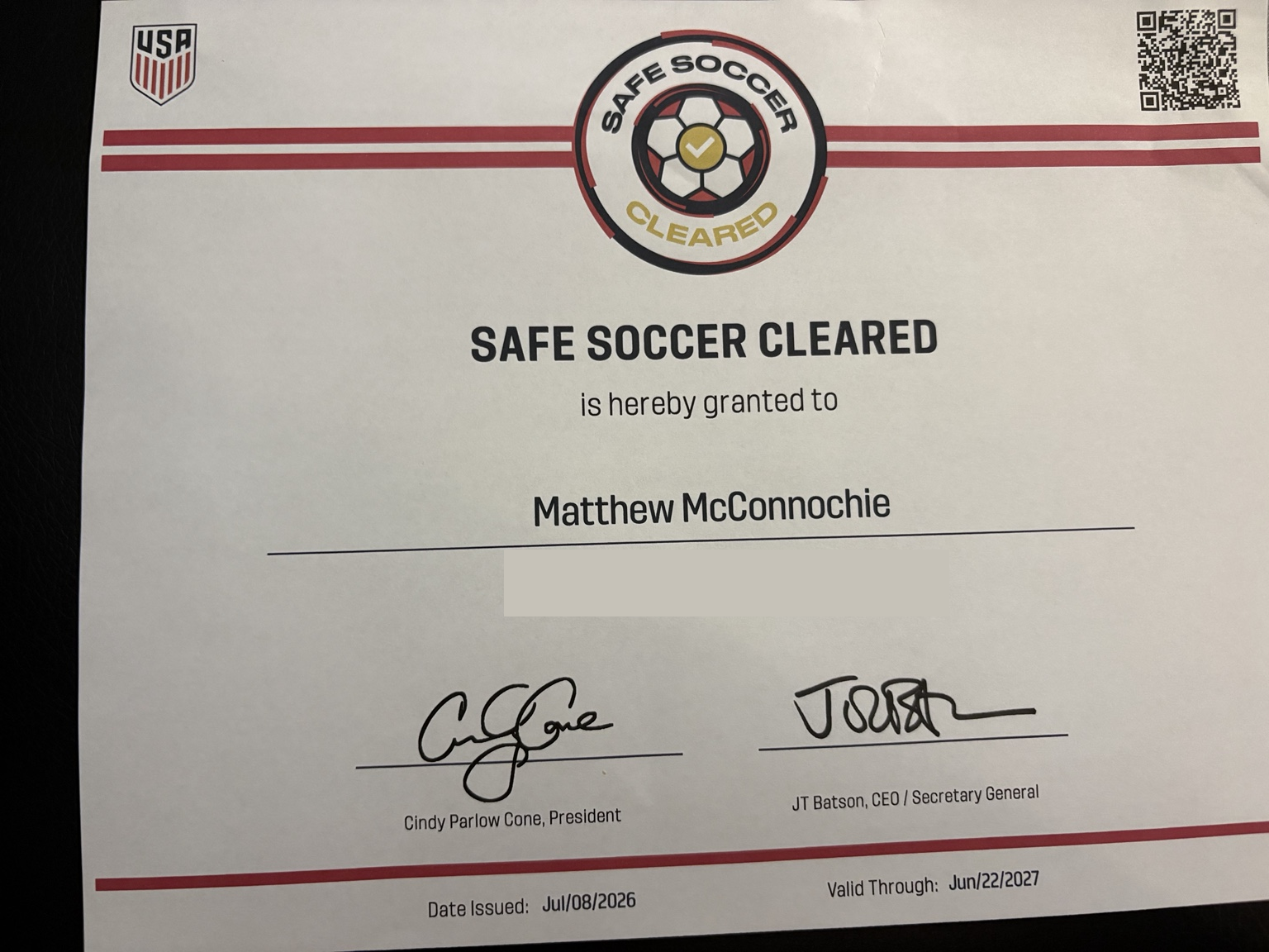 Constancia de U.S. Soccer que acredita a Matthew McConnochie como Safe Soccer Cleared; se ocultó el identificador personal y el código QR permanece visible.